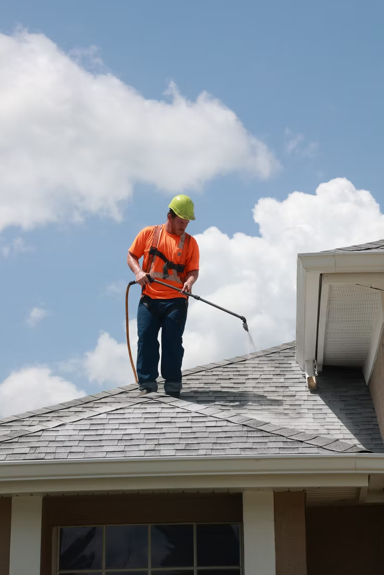 Technician applying roof rejuvenation treatment